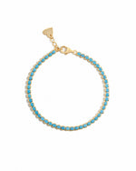 turquoise tennis bracelet in gold on a white background