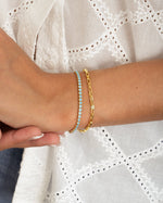 turquoise tennis bracelet stacked in gold on model
