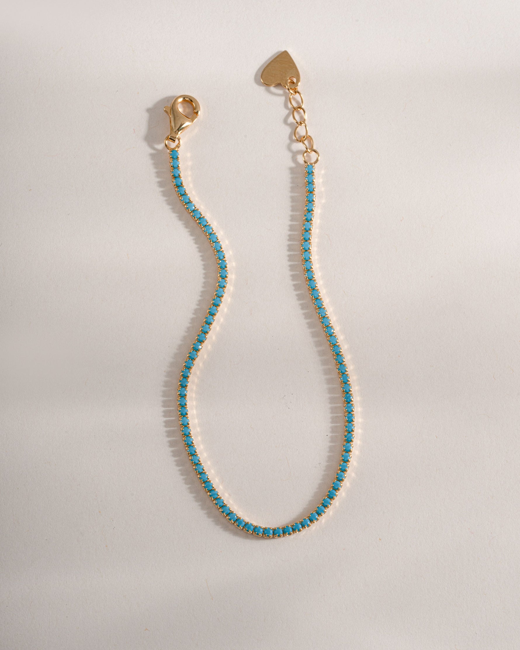 Turquoise tennis bracelet by Sami Jewels featuring gold accents and a row of vibrant turquoise stones on a delicate bracelet.