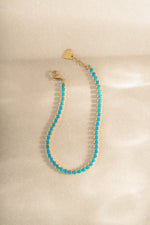 Sami Jewels 3mm turquoise tennis bracelet with gold links, showcasing vibrant turquoise stones on a delicate bracelet.
