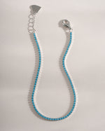 Close-up of Sami Jewels turquoise tennis bracelet featuring sterling silver setting with vibrant turquoise stones.