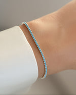 Turquoise sterling silver tennis bracelet by Sami Jewels worn on a model's wrist, featuring vibrant turquoise stones and elegant design.