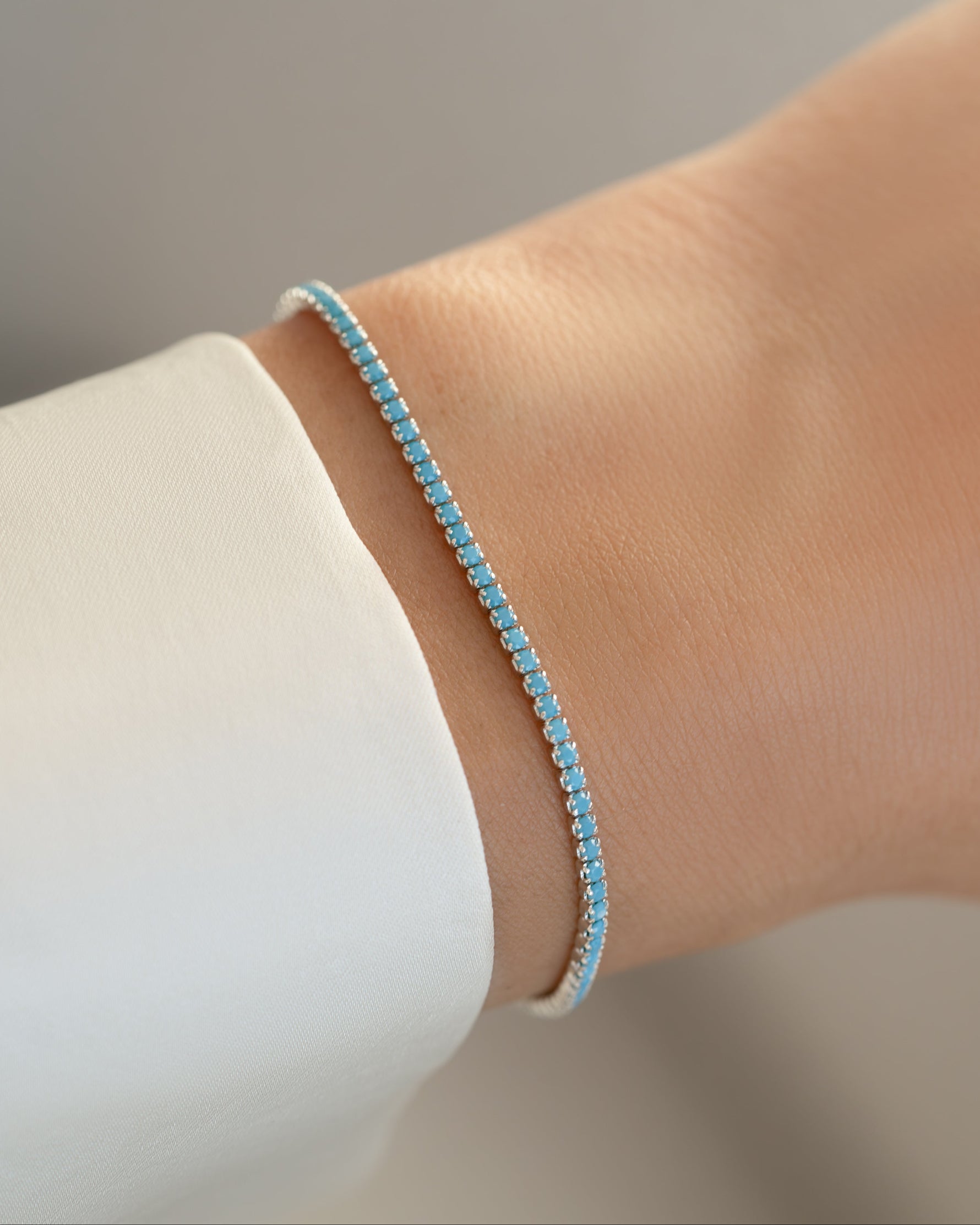 Turquoise sterling silver tennis bracelet by Sami Jewels worn on a model's wrist, featuring vibrant turquoise stones and elegant design.