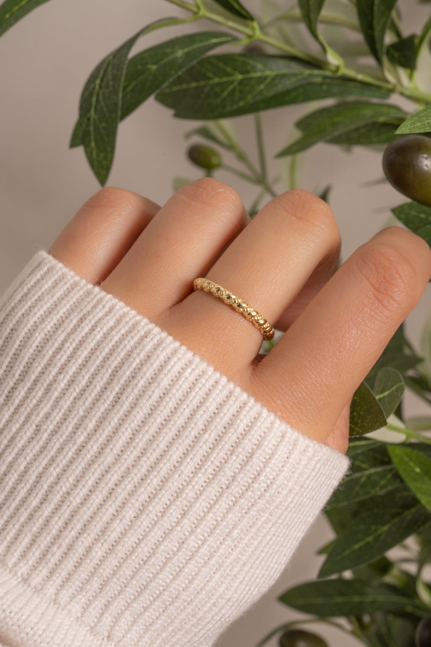 Gold Twist Stacking Ring by Sami Jewels, showcasing a sleek, intertwined design worn on a model's finger.