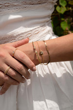 Gold twisted bangle cuff bracelet by Sami Jewels featuring a sleek, modern design on a model.