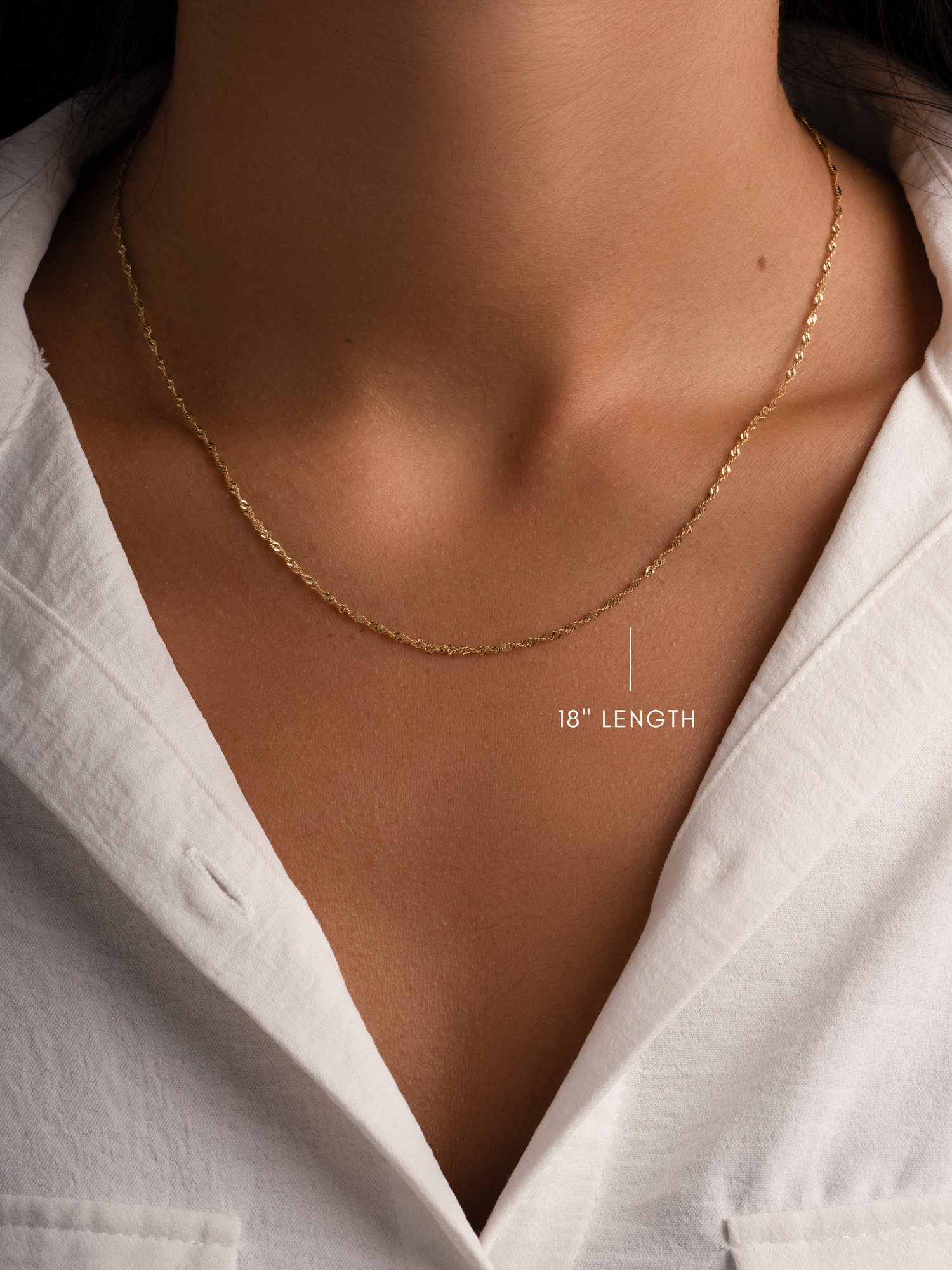 Gold 18-inch thin twisted chain necklace by Sami Jewels featuring a delicate, lightweight design on a model.