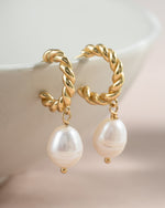 Gold spiral pearl drop earrings from Sami Jewels featuring twisted hoops with elegant pearl charms, close-up view.