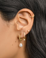 Gold spiral pearl drop earrings by Sami Jewels featuring twisted hoop design and elegant pearl charms.