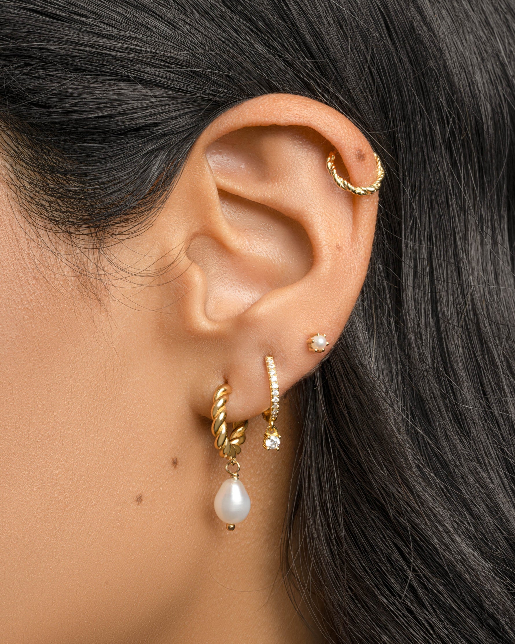 Gold spiral pearl drop earrings by Sami Jewels featuring twisted hoop design and elegant pearl charms.