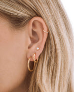 Gold stainless steel SS Twisted Hoops earrings by Sami Jewels, featuring a sleek twisted hoop design on a model.