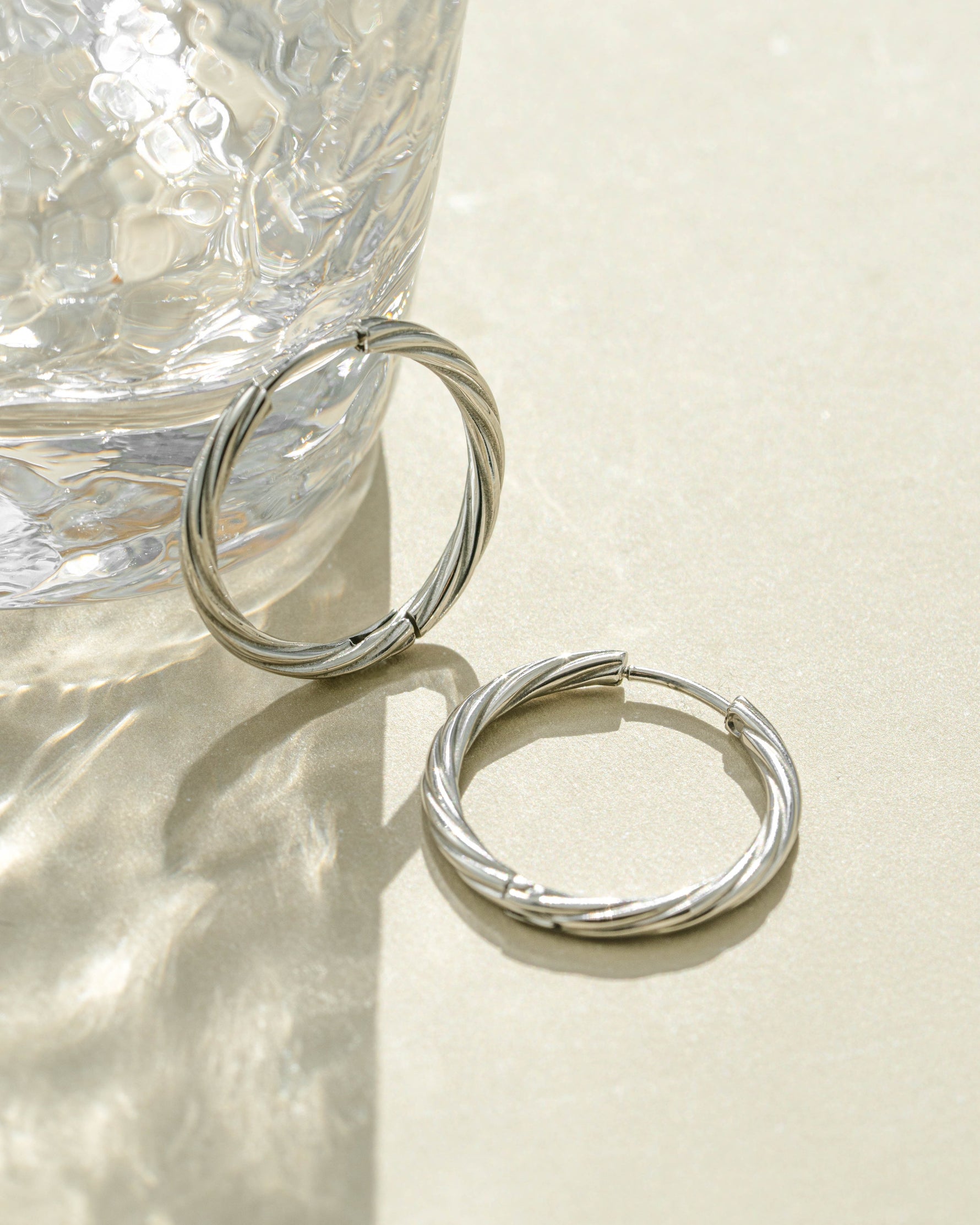 Silver stainless steel SS Twisted Hoops earrings by Sami Jewels, featuring a twisted hoop design and waterproof finish.