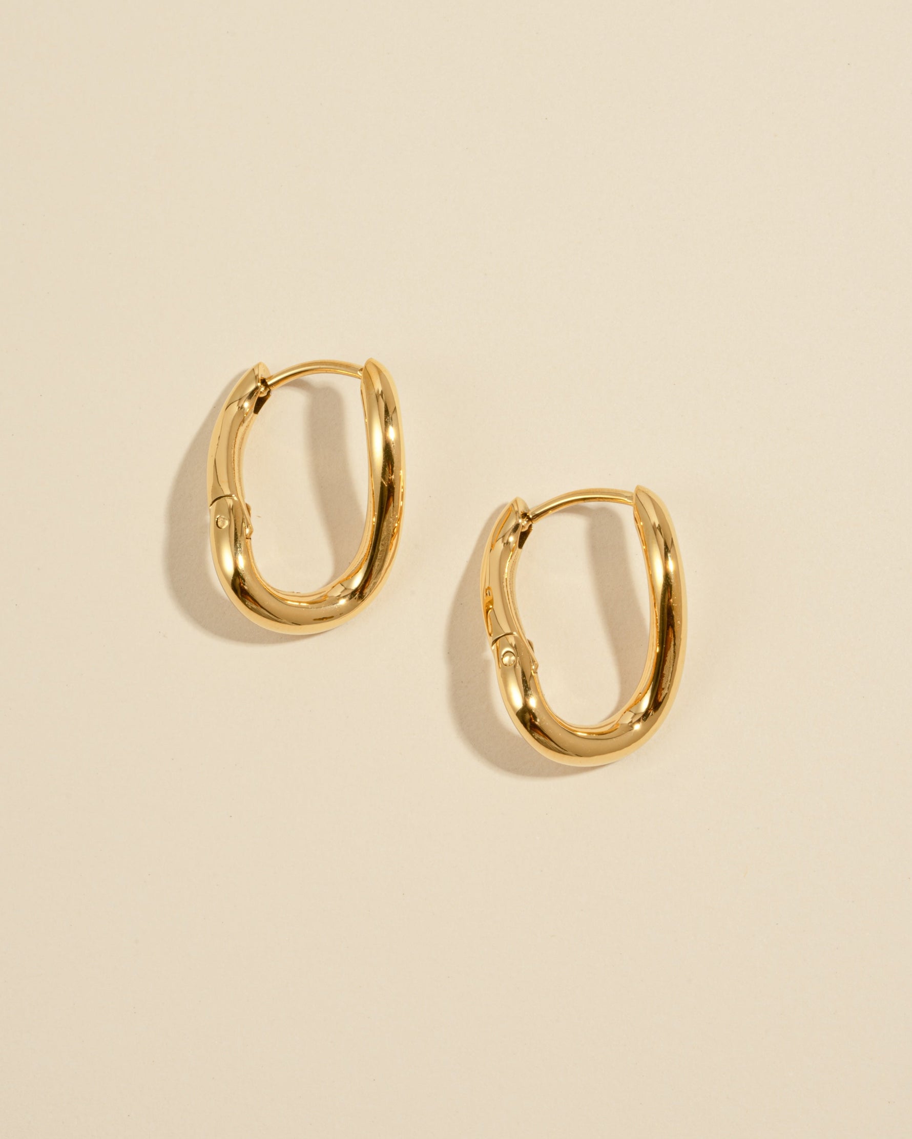 Gold stainless steel SS twisted oval hoop earrings by Sami Jewels, featuring a sleek, waterproof design with a modern twisted oval shape.