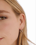 Silver stainless steel SS twisted oval hoops earrings by Sami Jewels, shown on a model with a sleek, modern design.