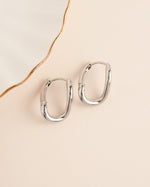 Silver stainless steel SS twisted oval hoop earrings by Sami Jewels with a sleek, waterproof design.