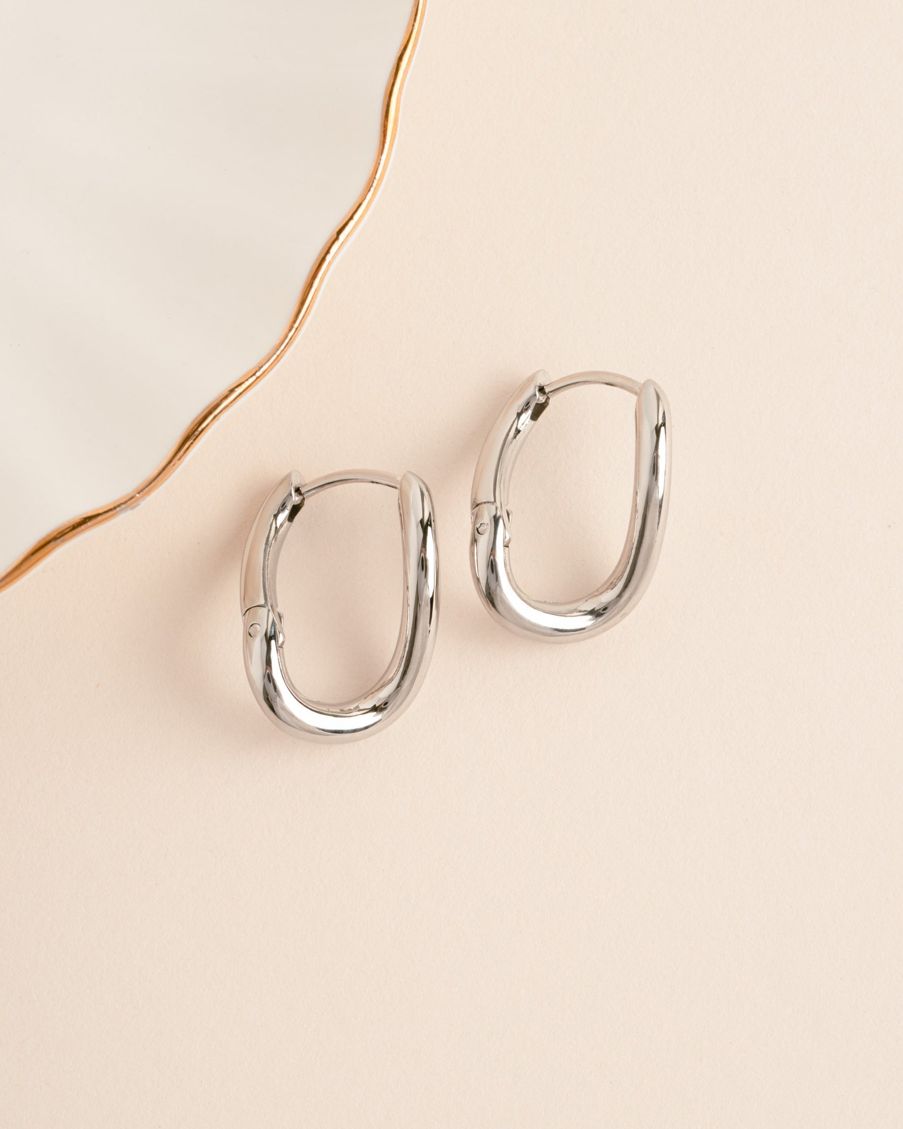 Silver stainless steel SS twisted oval hoop earrings by Sami Jewels with a sleek, waterproof design.