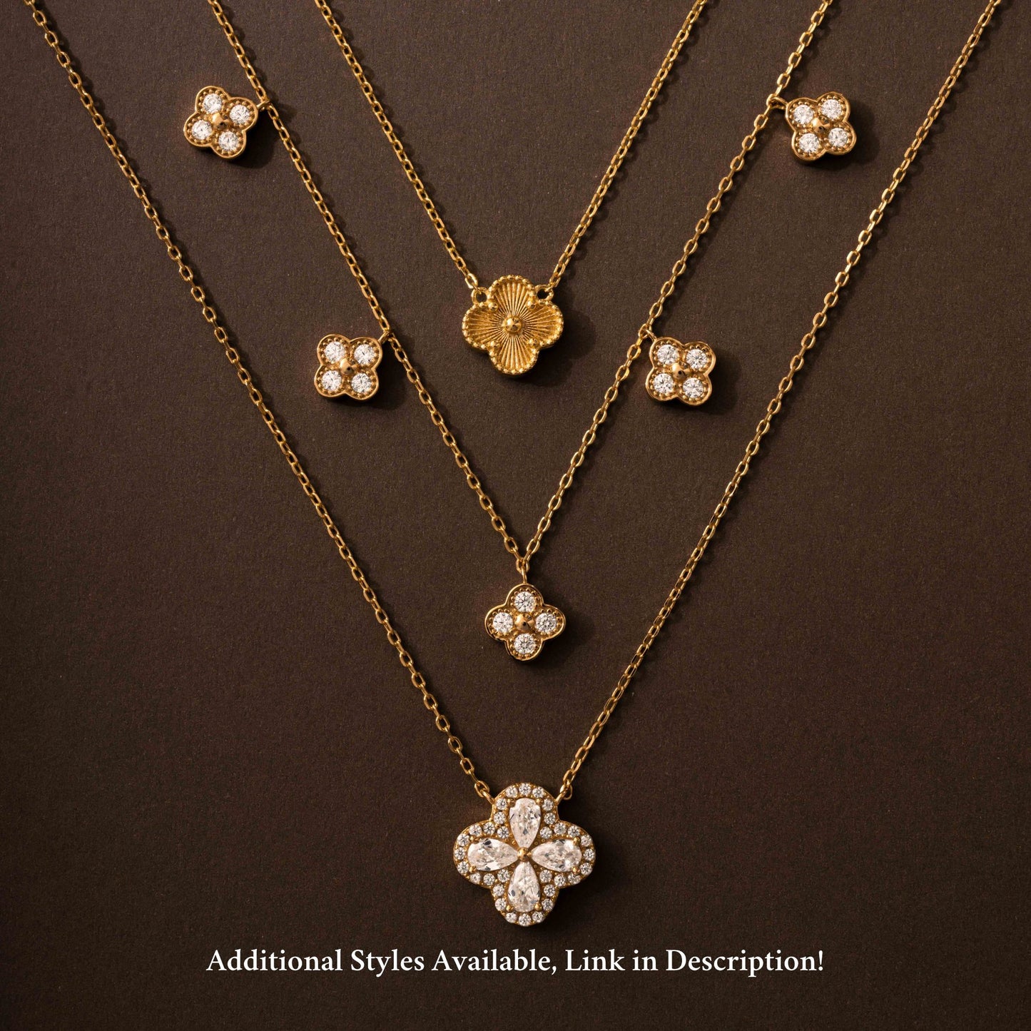 flat lay of three four leaf clover necklaces inspired by van cleef, one with an intricate patter, another one with four leaf clover charms and then another four leaf clover pendant with pear shaped stones surrounded by pave stones