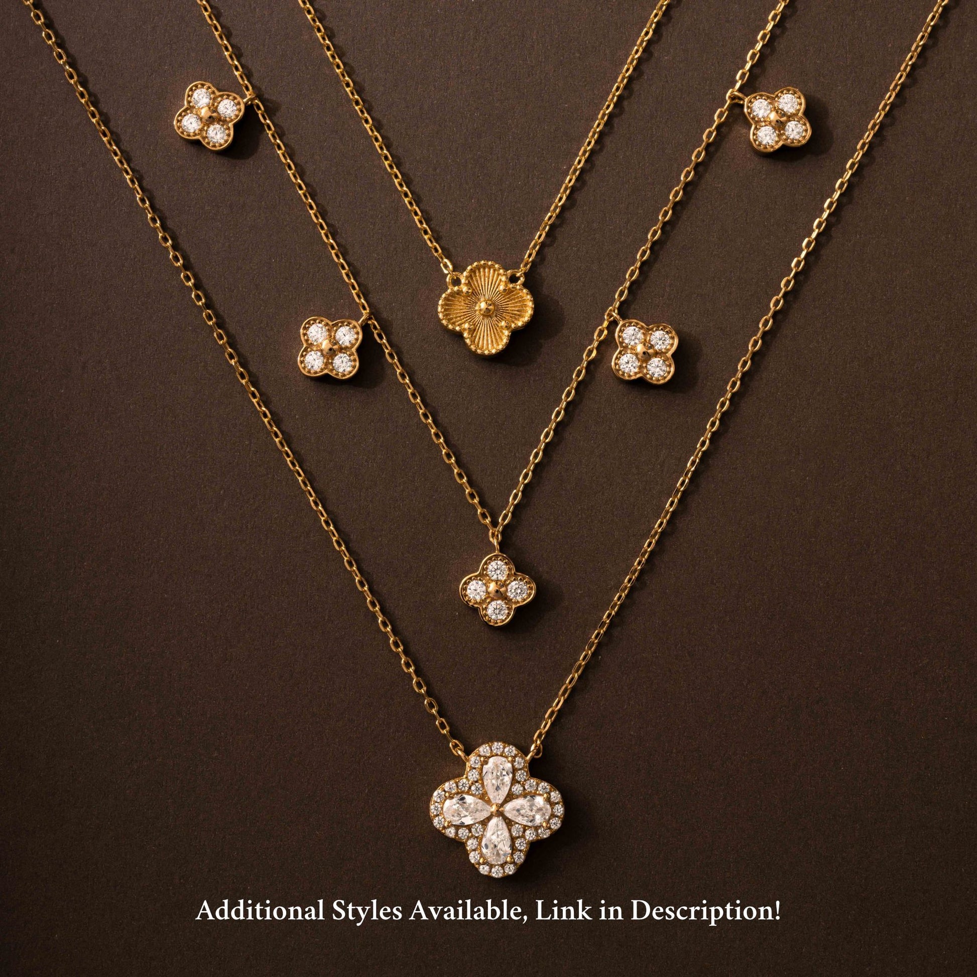 Flat lay of four leaf clover necklace designs, like single charm diamond necklace, five charm clover necklace with diamond charms and dainty single four leaf clover necklace.