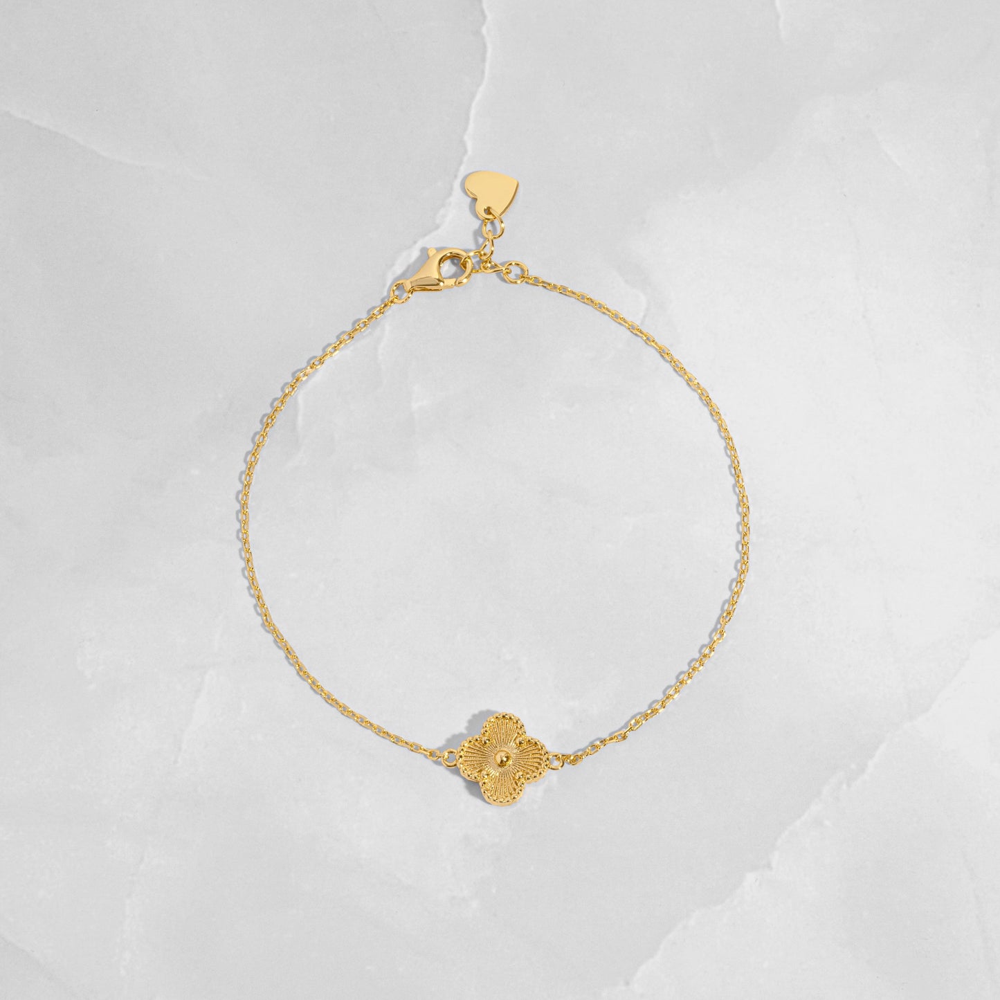 flat lay of a single charm gold clover bracelet