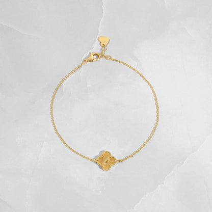 flat lay of a single charm gold clover bracelet