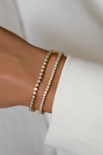 Classic tennis and round bezel tennis bracelets in gold vermeil stacked on the wrist
