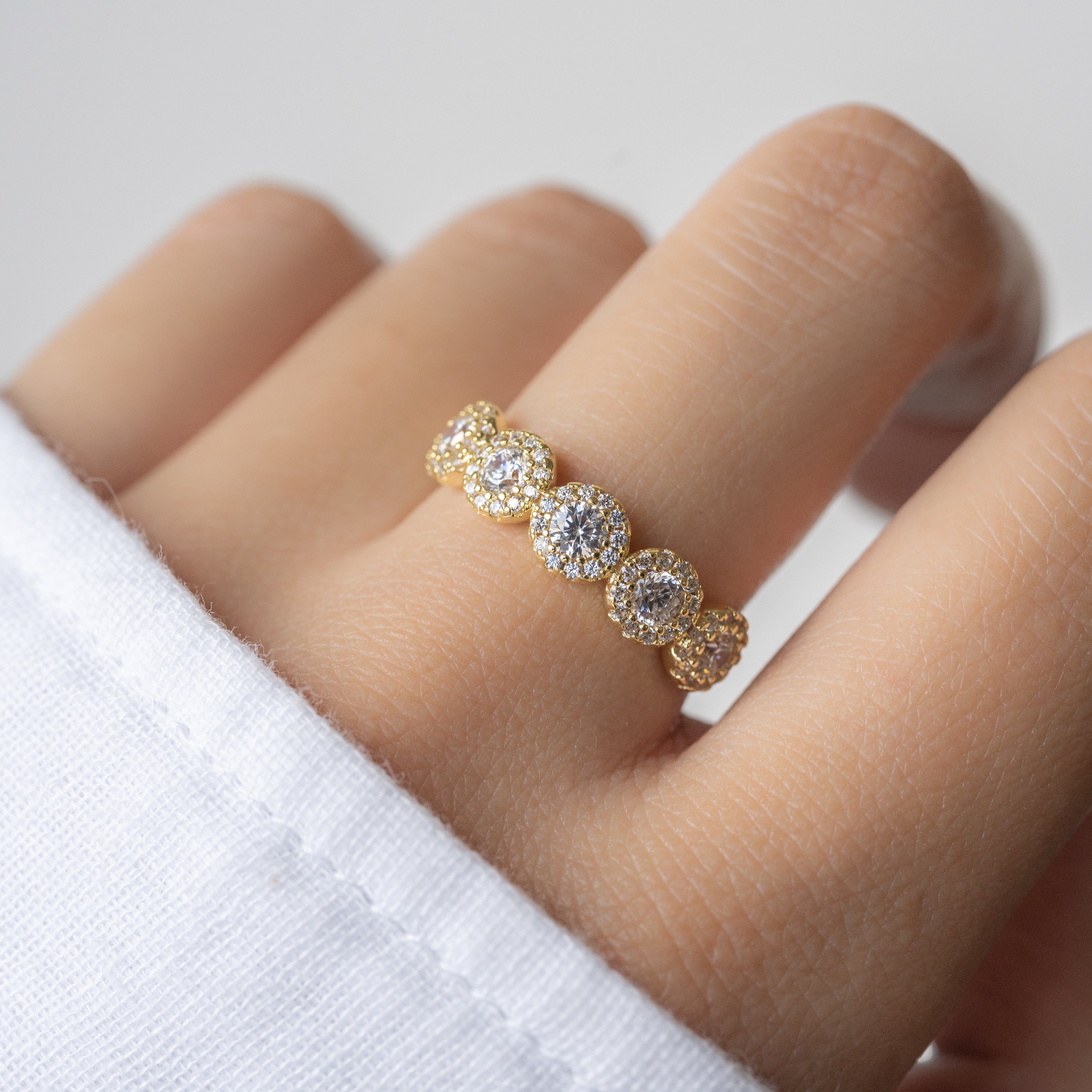 Sami Jewels 5 stone halo ring featuring a band with five sparkling stones and a delicate halo design.