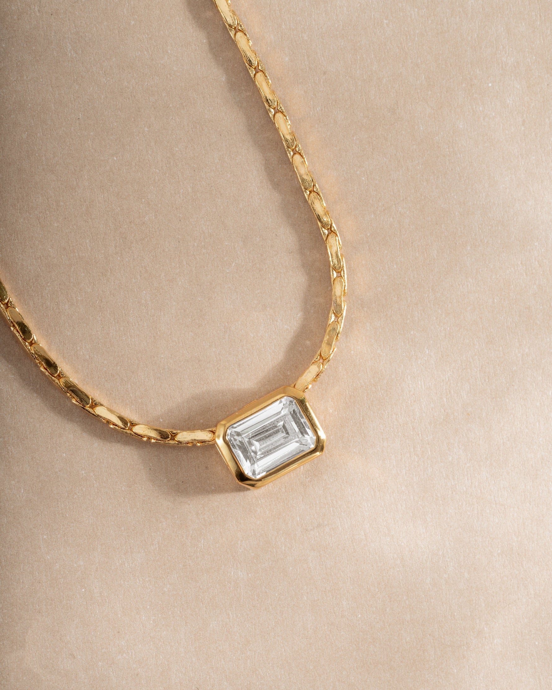 Close-up of Sami Jewels white CZ baguette bezel statement necklace with gold chain, showcasing sparkling cubic zirconia details.