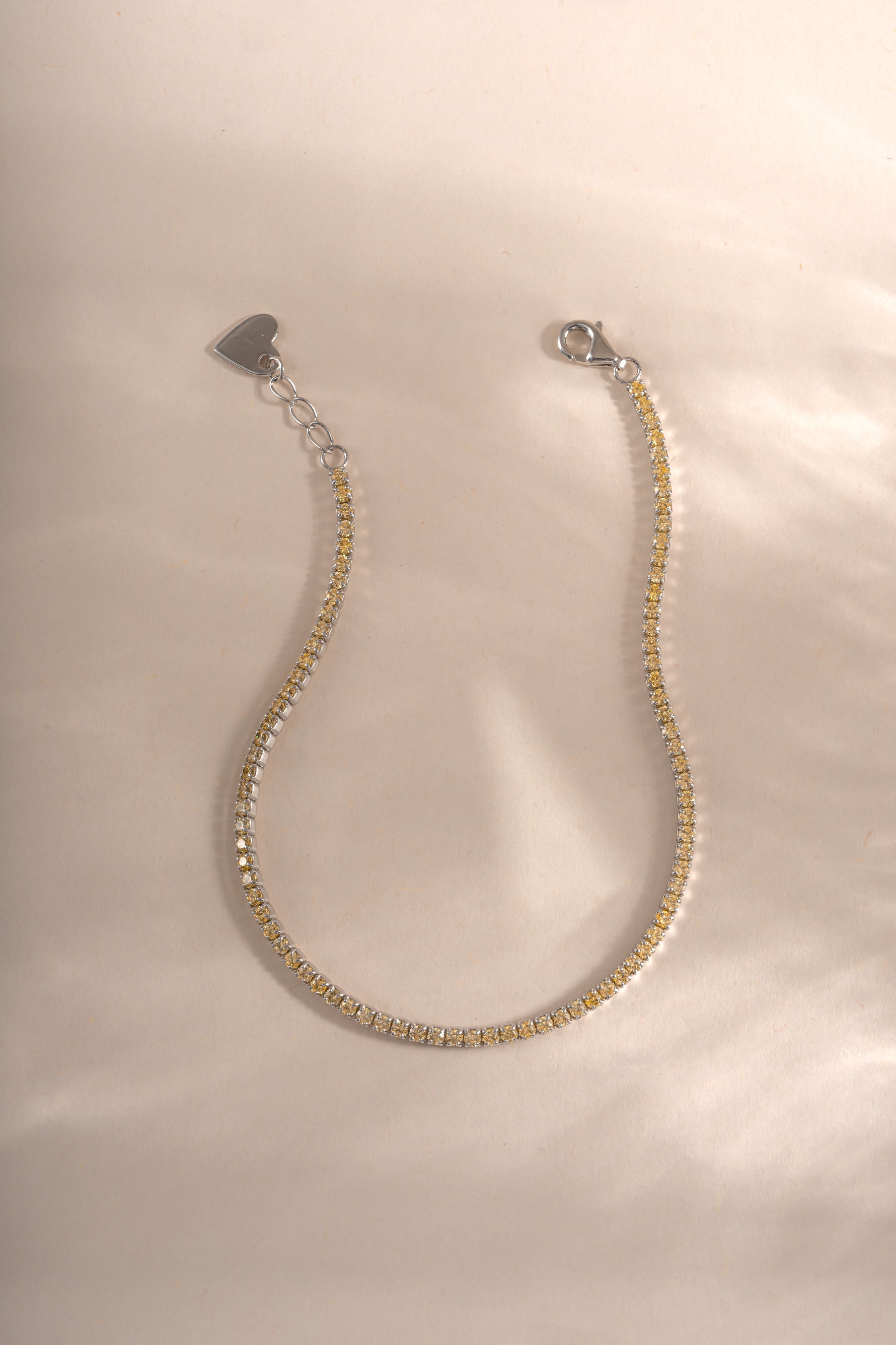 Yellow diamond tennis bracelet by Sami Jewels featuring sterling silver with a lobster clasp closure and sparkling diamonds.
