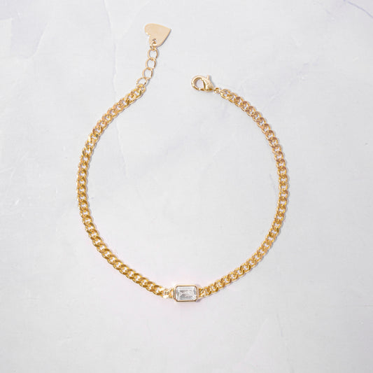 diamond bezel baguette charm on gold curb chain bracelet