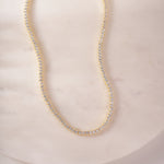 a white marble table with a necklace on it