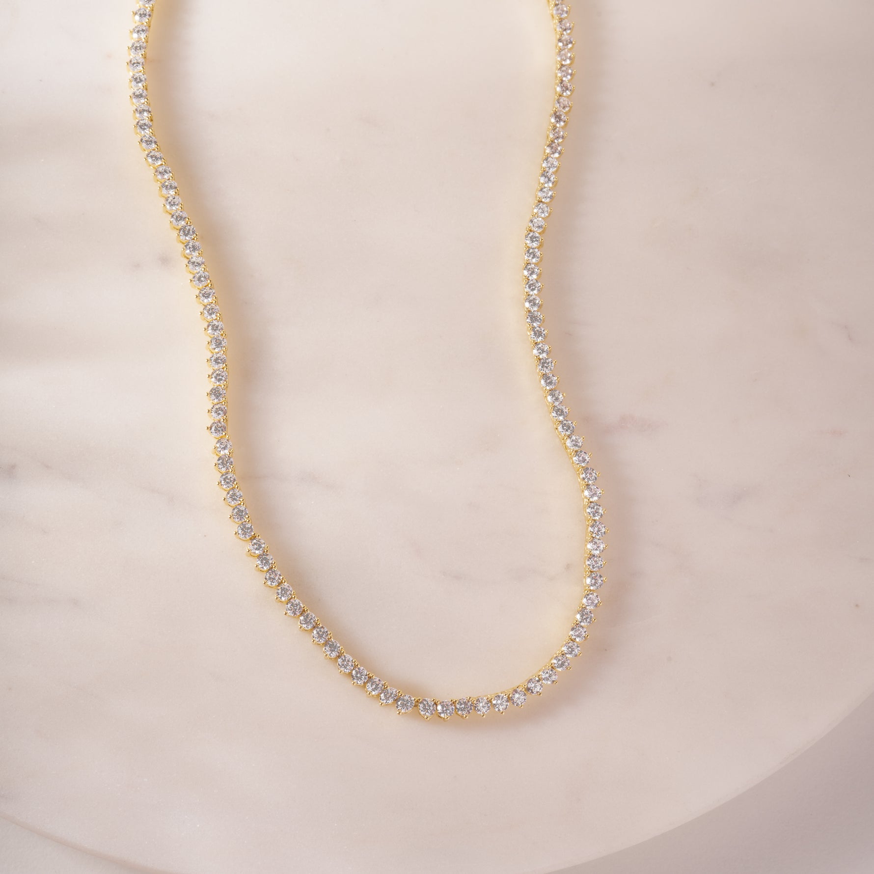 a white marble table with a necklace on it
