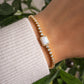 model wearing gold opal charm tennis bracelet