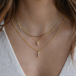 Diamond cross pendant necklace layered on model for a chic, minimalist look.