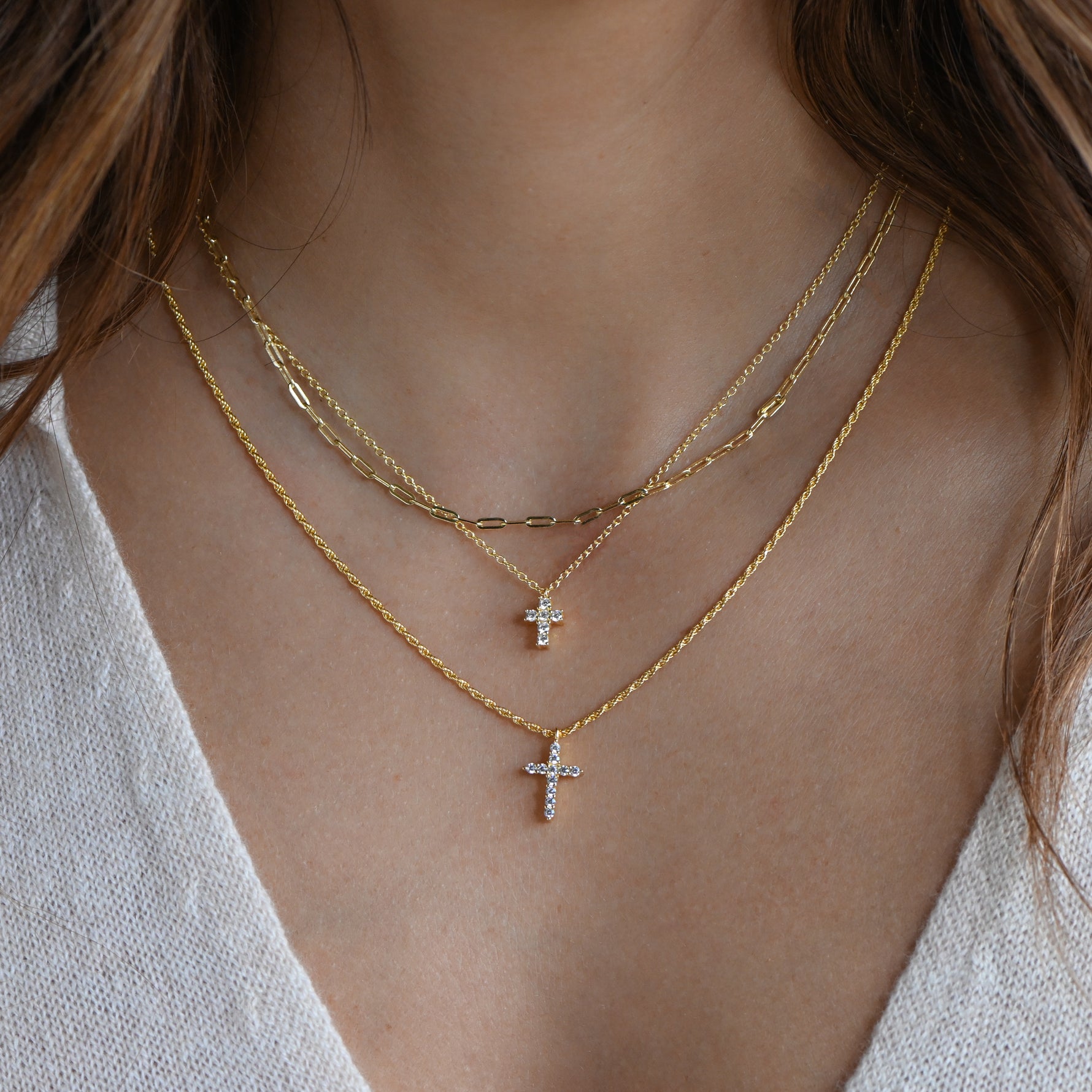 Diamond cross pendant necklace layered on model for a chic, minimalist look.