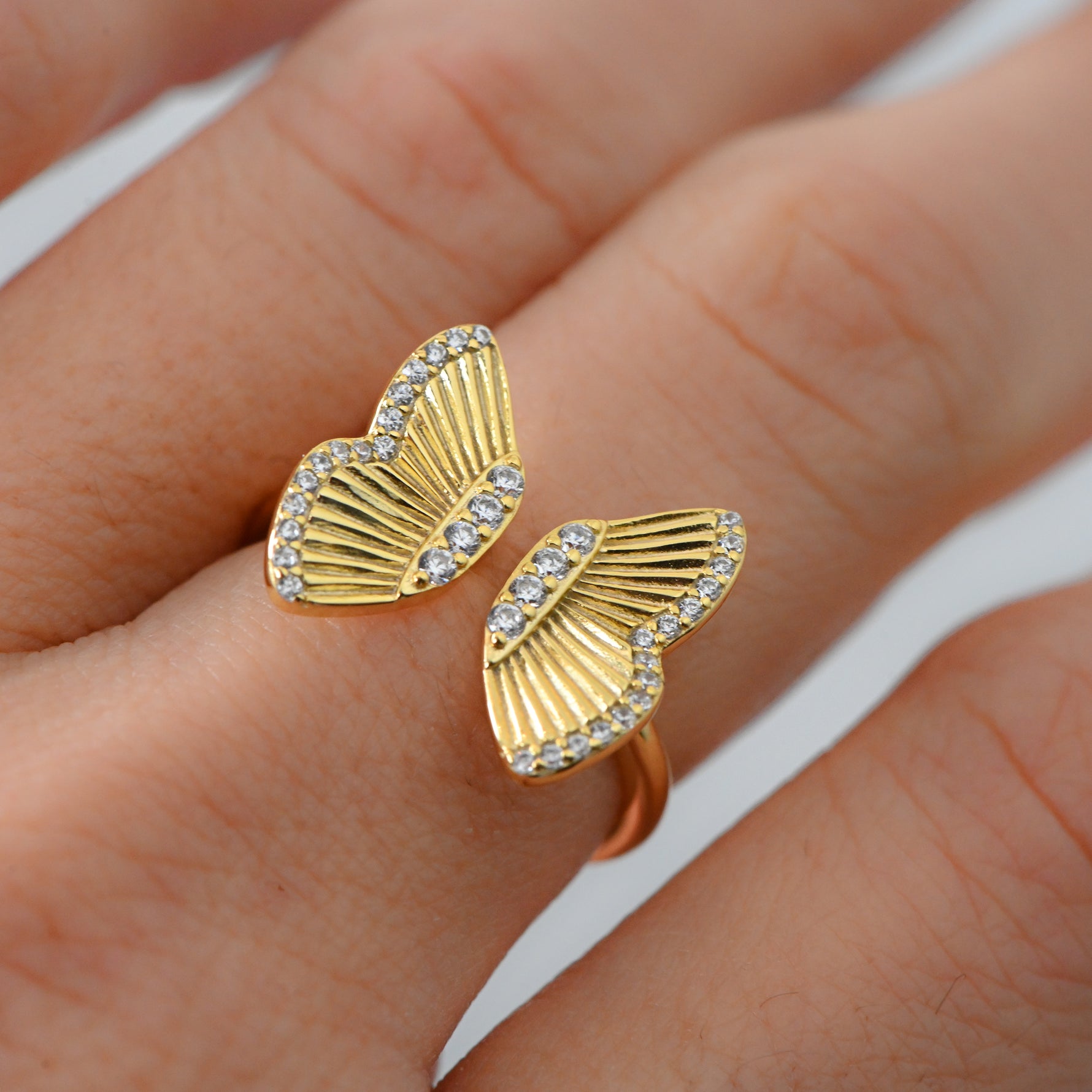 Upclose shot of gold adjustable butterfly ring. 