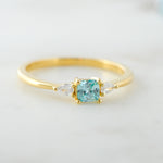 Upclose image of aquamarine cushion cz ring in gold. 