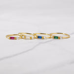 Dainty birthstone rings in gold featuring ruby, diamond, sapphire, and emerald stones. 