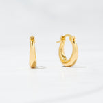 Gold mini basket huggies on plain background.
