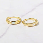 Opal and CZ oval bezeled dome rings in gold on marble background. 
