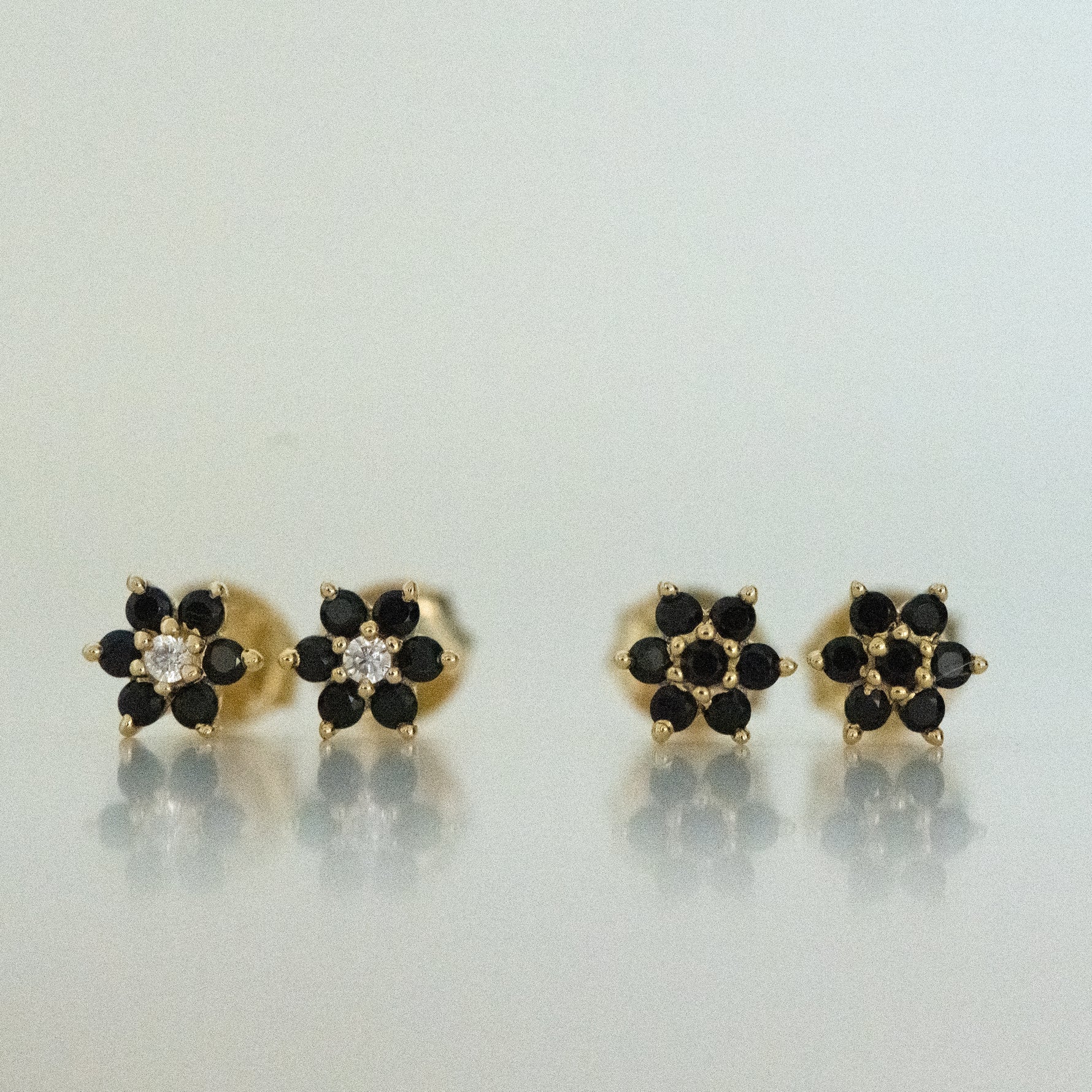 Black onyx flower stud earrings with a white diamond center and in solid black.