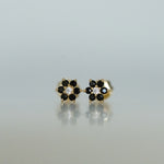 Upclose shot of black onyx flower stud earrings with white diamond center. 