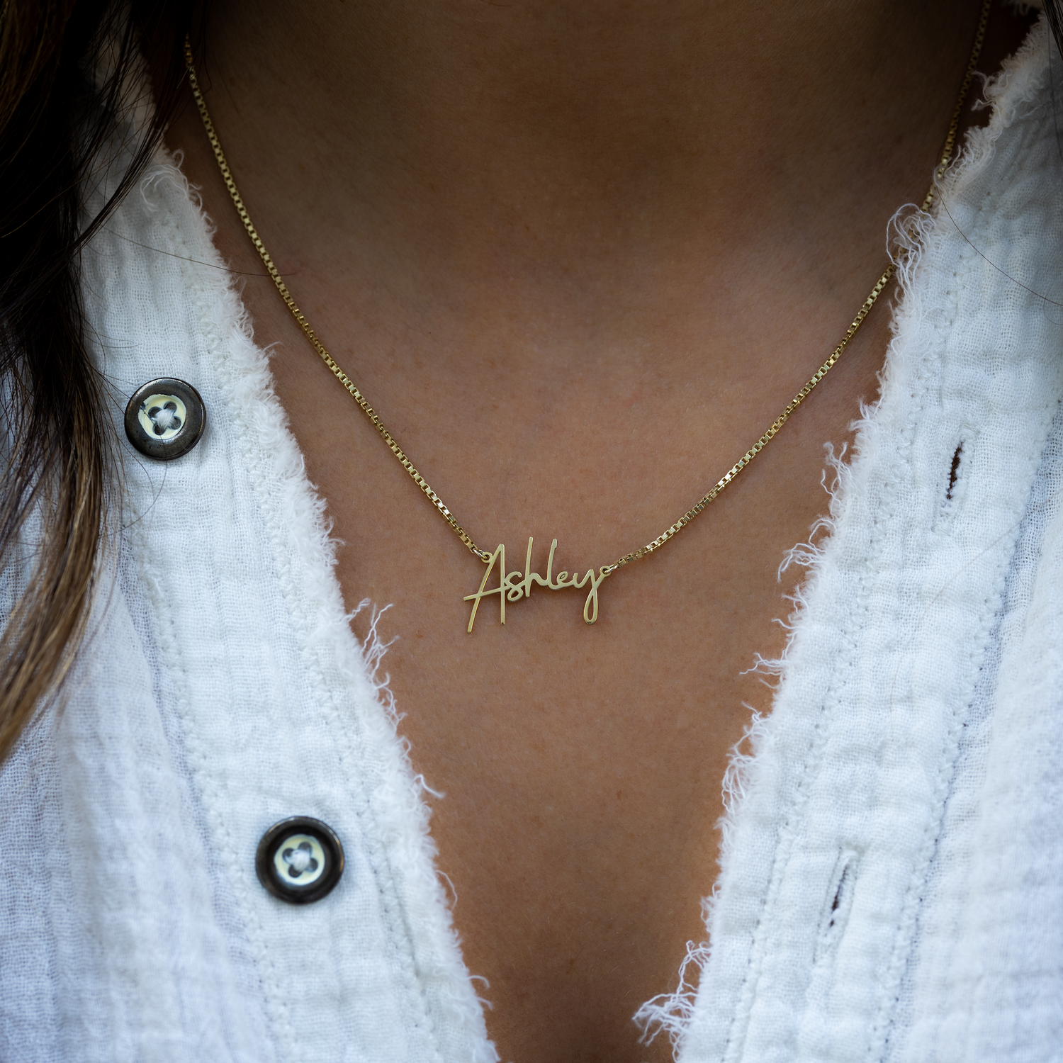 Model wearing gold script custom name necklace with box chain