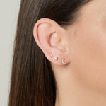 Model wearing gold celestial minimalist stud earrings stack featuring a lightning bolt, a star, and a CZ moon stud. 