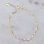 Gold shiny plain ankle bracelet on marble background