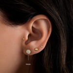 Model wearing cluster diamond gold stud earring, gold ball stud, and a tiny gold ball stud.