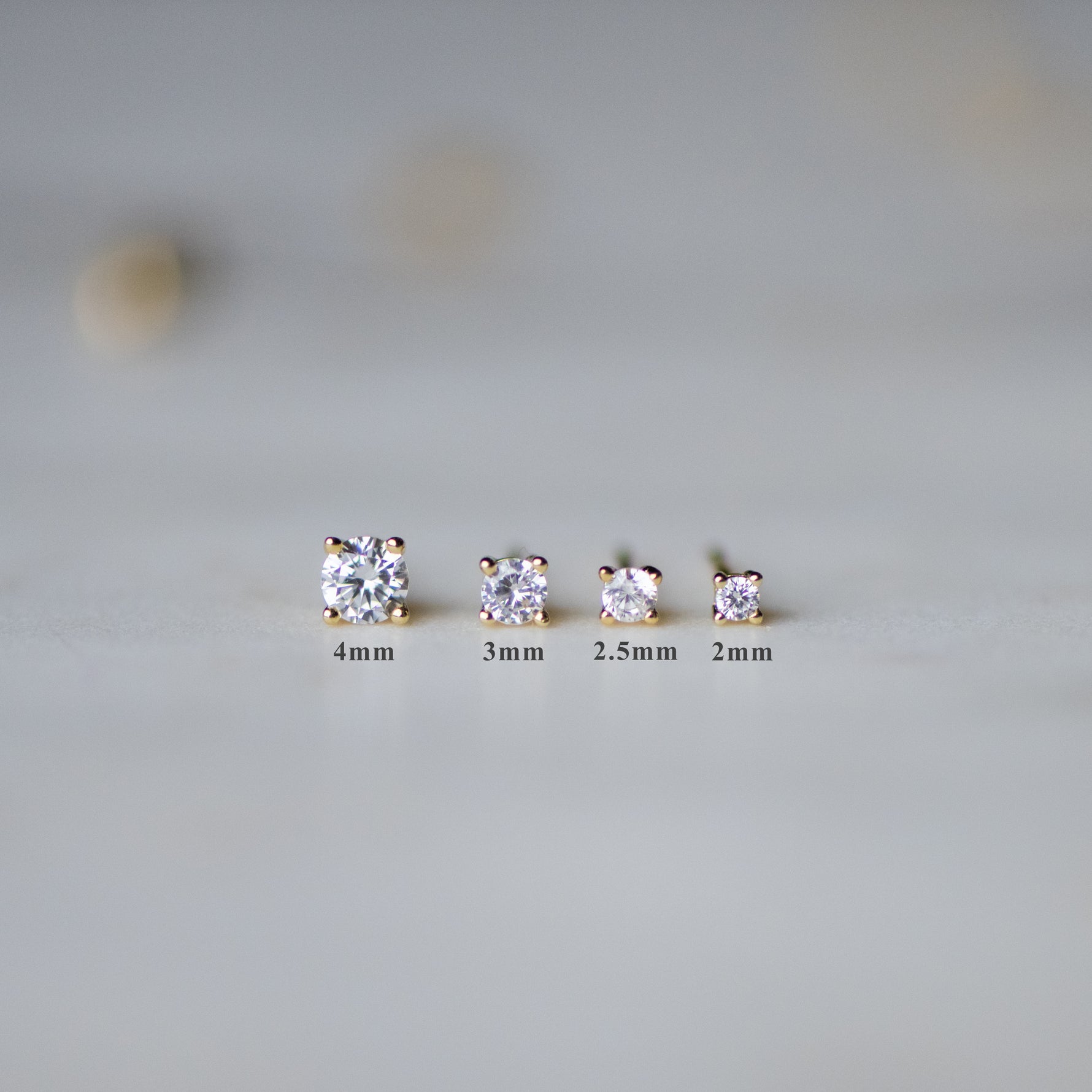 Gold stud earrings in multiple different sizes. 