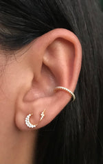 Moon celestial earring stack featuring a moon, a lightning bolt, and a cz ear cuff on a model. 