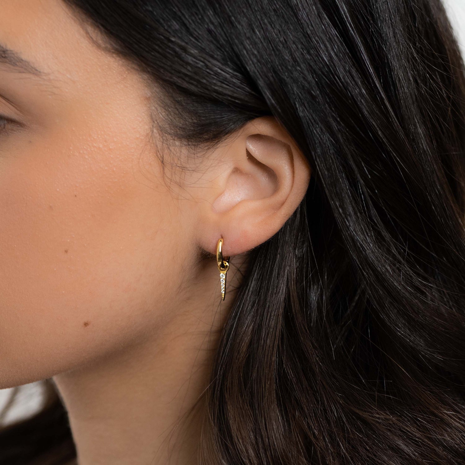 Model wearing gold cz spike charm huggies