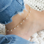 Model wearing pearl charm ankle bracelet with jeans