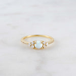 Opal cluster ring with cz stones on marble background. 