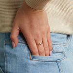 Model wearing delicate gold ring with solitaire pear cz diamond.